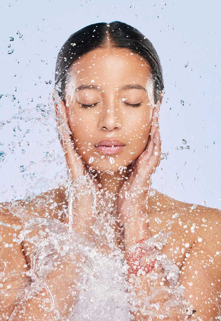 young woman splashing water on herself