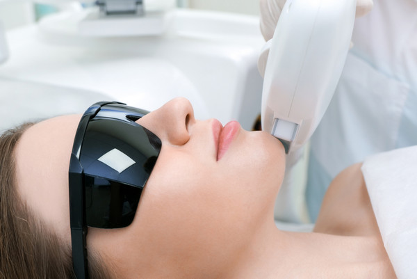 young woman getting laser hair removal treatment on upper lip